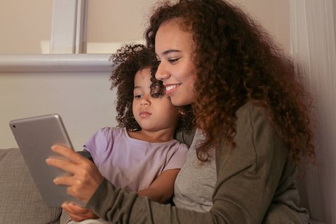Image of adult and child using a tablet together